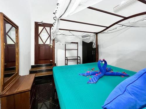 een slaapkamer met een bed met een blauw laken en een hemelbed bij Bora Bora Villa in Hikkaduwa