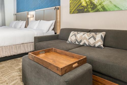 a living room with a couch and a bed at SpringHill Suites by Marriott Freeport Brunswick in Freeport