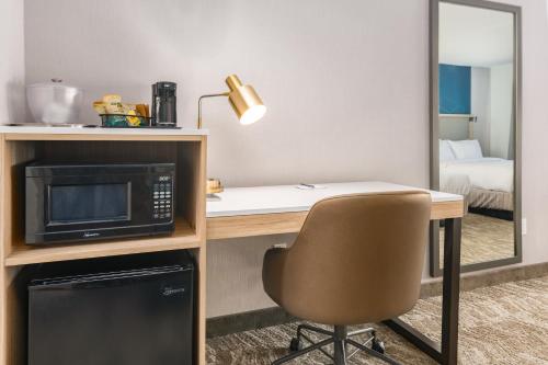 a room with a desk with a microwave and a chair at SpringHill Suites by Marriott Freeport Brunswick in Freeport