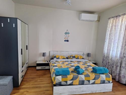 a bedroom with a bed with blue pillows on it at Studio Anelia in Sveti Vlas