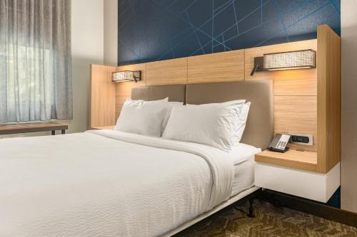 a bedroom with a large bed with a blue wall at SpringHill Suites by Marriott Freeport Brunswick in Freeport