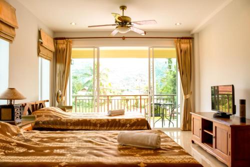 a bedroom with two beds and a balcony at Baan Rosa Bangtao Beach in Bang Tao Beach