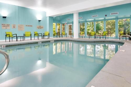 a swimming pool with yellow chairs and tables at SpringHill Suites by Marriott Freeport Brunswick in Freeport
