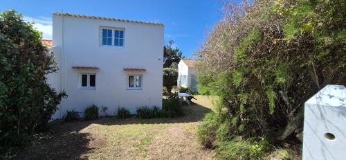 une maison blanche au milieu d'une cour dans l'établissement Maison de famille bord de mer, à Ker Pierre Borny