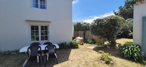 une table et des chaises assises à l'extérieur d'une maison dans l'établissement Maison de famille bord de mer, à Ker Pierre Borny