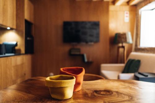 a wooden table with two cups on top of it at Story Studio Sortelha - Heritage in Sortelha