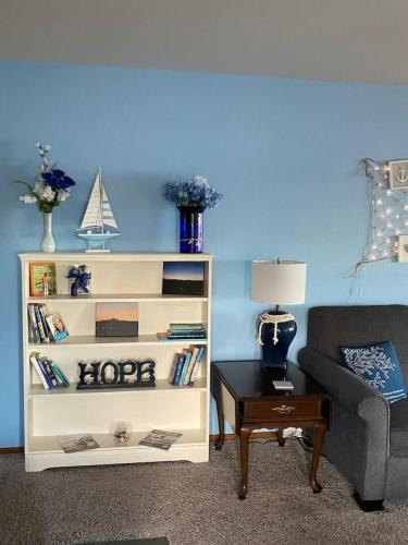 a living room with a white book shelf next to a couch at View WD Downtown Harbor R and R in Oak Harbor