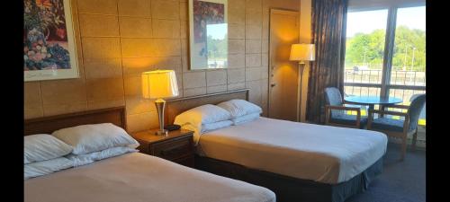a hotel room with two beds and a window at The Inn At Lock Seven in Thorold