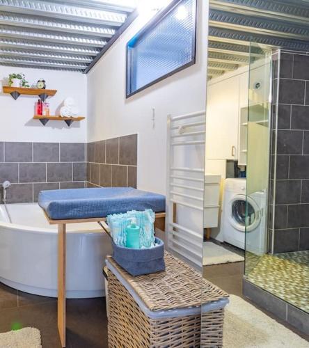 La salle de bains est pourvue d'une baignoire, d'un lavabo et d'un lave-linge. dans l'établissement Le Loft Indus - Parking - Borne arcade - BBQ - Salle de jeux - WIFI, à Sainte-Savine