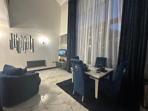a room with a desk with a computer and chairs at Two Bedroom Apartment in Slough
