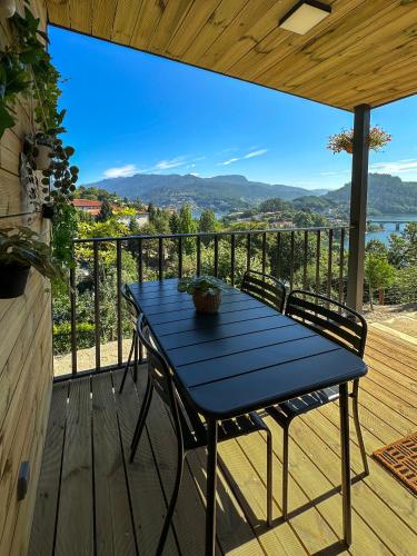 a blue table and chairs on a deck with a view at Bungalow Bétula - Pichoses Camping - Gerês in Rio Caldo