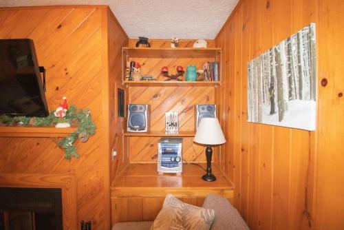 a living room with wooden walls and a tv and a lamp at Stemwinder 5 Spacious Townhome Short Distance to Powder Monkey Lift in Snowshoe