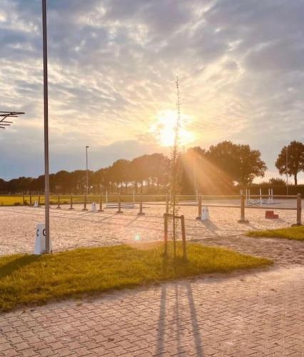 a park with a playground with the sun shining at Holiday home in Arriën