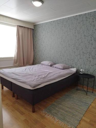 a bed in a bedroom with a wall at SAGA Modern Apartment with 24-7 Check-in in Kristiinankaupunki