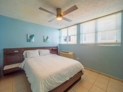 a bedroom with a bed with a ceiling fan at Olas Del Mar Beach Apartment in Luquillo