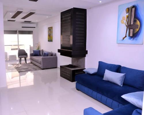 a living room with a blue couch and a fireplace at Appartement duplex très chic in Ville Nouvelle