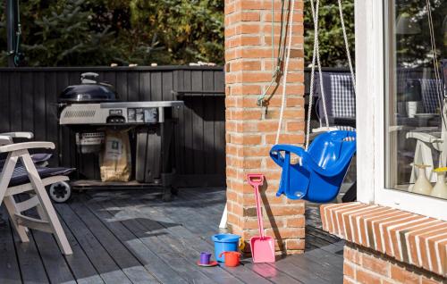 a patio with a grill and a chair and a table at Cozy Home In Fjerritslev With Wifi in Fjerritslev