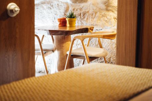 a table and chairs with a potted plant on it at Story Studio Sortelha - Heritage in Sortelha