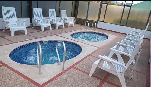 a patio with chairs and a swimming pool with chairs and tables at Feliz Amanecer in Sáchica