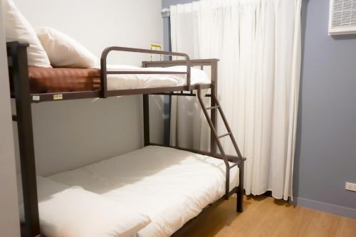 two bunk beds in a room with a window at Alea Residences in Manila