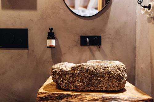 a rock sitting on a table with a mirror at Story Studio Sortelha - Heritage in Sortelha