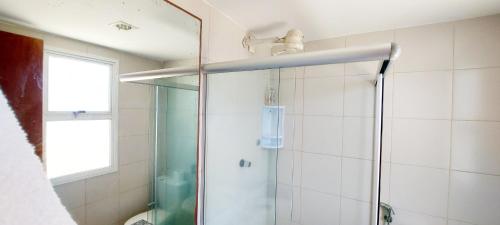 eine Dusche mit einer Glastür in einem Badezimmer in der Unterkunft COARE0101 - Condominio Aldeia Saint Sebastien in Arembepe