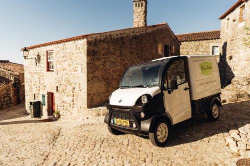 a small van parked in front of a building at Story Studio Sortelha - Heritage in Sortelha