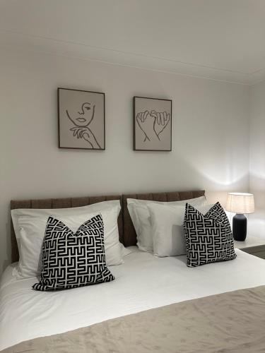 a bedroom with a bed with three pictures on the wall at The Snug - Town Centre Apartment in Bishops Stortford