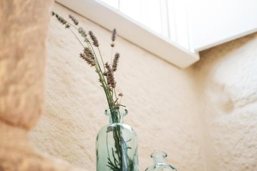 a glass vase with flowers in it on a shelf at Story Studio Sortelha - Heritage in Sortelha