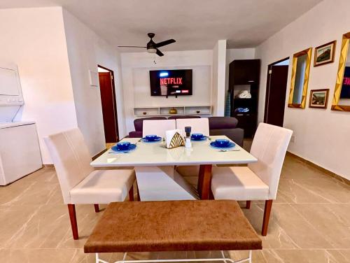a dining room with a white table and white chairs at Ocean Front Apartments in Arecibo