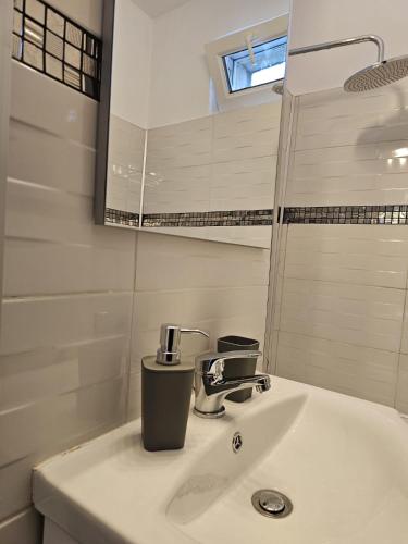 un baño con lavabo y espejo en Hortensia Apartment, en Tomis Nord
