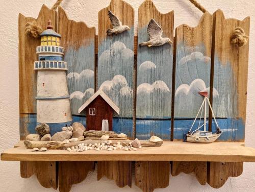 a wooden shelf with a painting of a lighthouse at Ocean Front Apartments in Arecibo
