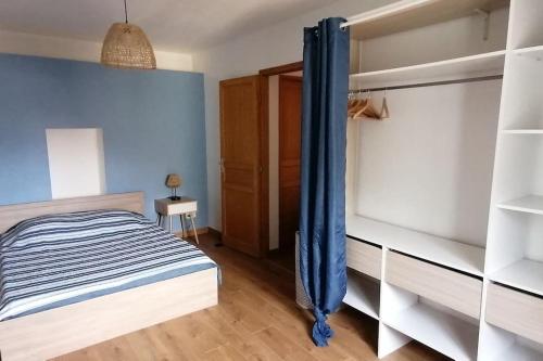 a bedroom with a bed with blue walls at Les Roses Trémières in Saujon