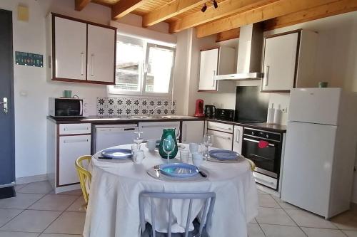 une cuisine avec une table et un chiffon de table blanc dans l'établissement Les Roses Trémières, à Saujon