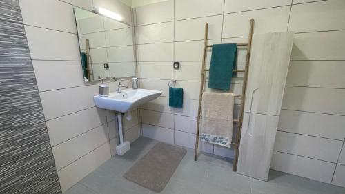 a bathroom with a sink and a mirror at El Dorado Ste Rose 3 étoiles in Sainte-Rose