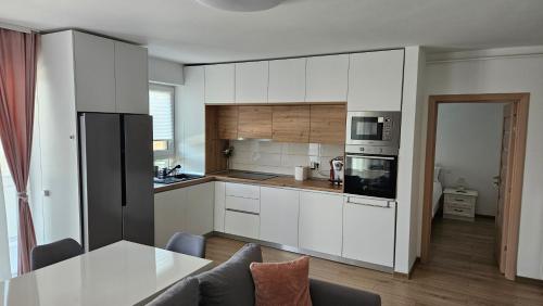 een keuken met witte kasten en een tafel in een kamer bij Goldmaurer in Târgu-Mureş