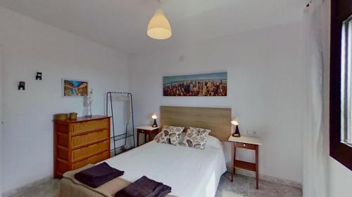 a bedroom with a bed and a dresser and a mirror at Villa Mirador del Mar hostel in Comarruga
