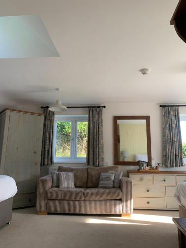 a living room with a couch and a mirror at Durdle Door Hotel in Lulworth Cove