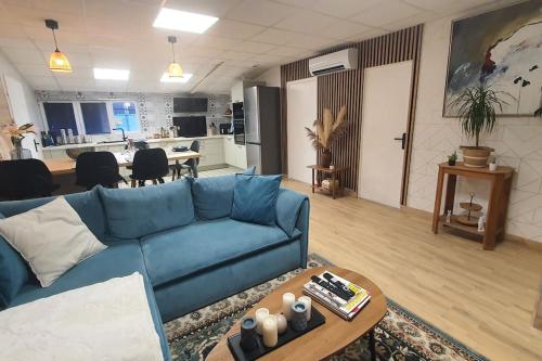 un salon avec un canapé bleu et une cuisine dans l'établissement Appartement cosy & fonctionnel !, à Lempdes