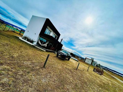 a house with a car parked next to the ocean at Casa Puerto del Águila in La Estancia