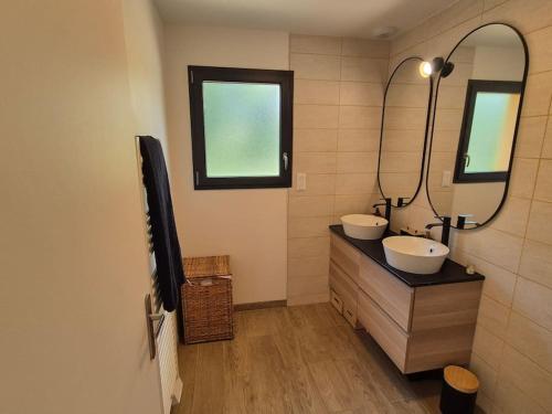 une salle de bain avec deux lavabos et un miroir dans l'établissement Maison au pied du Puy-de-Dôme, à Ceyssat