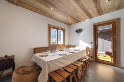 d'une salle à manger avec une grande table et des plafonds en bois. dans l'établissement Chalet La Datcha, aux Contamines-Montjoie