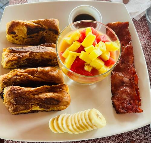 a plate of food with meat and fruit on it at Chateau Arenal Hotel & Restaurante in El Castillo de La Fortuna