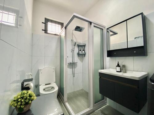 a bathroom with a shower and a toilet and a sink at Sunset Views 3-Bedroom Apt, 1min Walk to Beach - NYHA1 in Flic-en-Flac