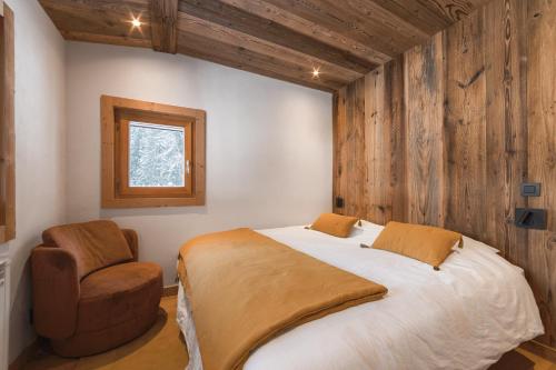 une chambre avec un lit et une chaise dans l'établissement Chalet La Datcha, aux Contamines-Montjoie