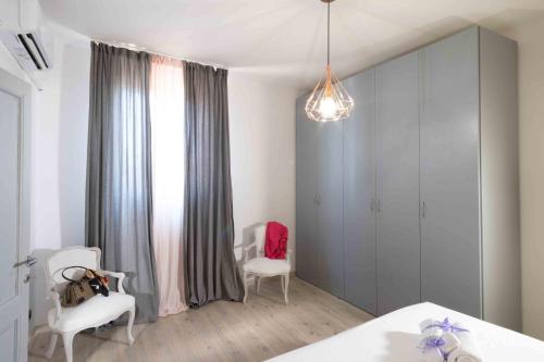 a bedroom with a bed and two chairs and a window at Lezioso, Apartments in Florence in Florence