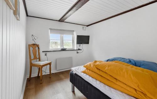 a bedroom with a bed and a chair and a window at 3 Bedroom Amazing Home In Sydals in Lebøl