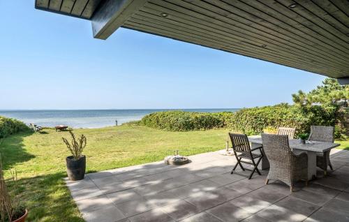 a patio with a table and chairs and the ocean at 3 Bedroom Lovely Home In Martofte in Martofte