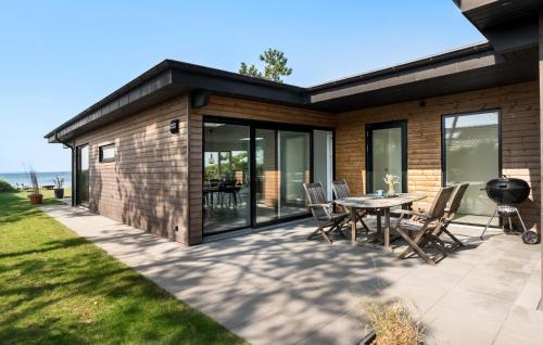 a house with a patio with a table and chairs at 3 Bedroom Lovely Home In Martofte in Martofte
