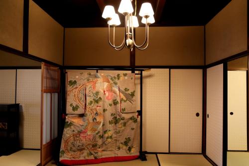 a large painting on a wall with a chandelier at Show-an Machiya Inn in Kyoto